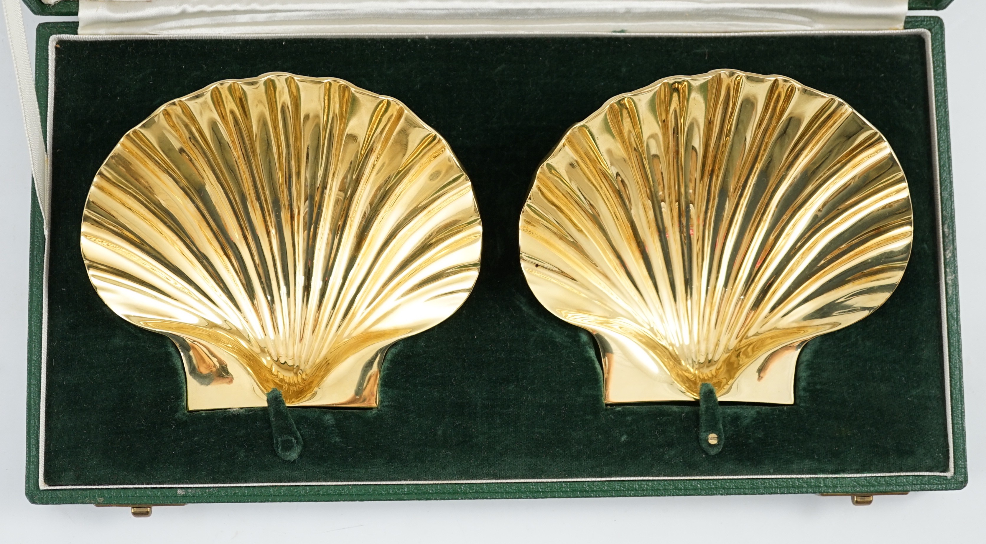A cased pair of Elizabeth II silver gilt scallop shell butter dishes by Collingwood & Co